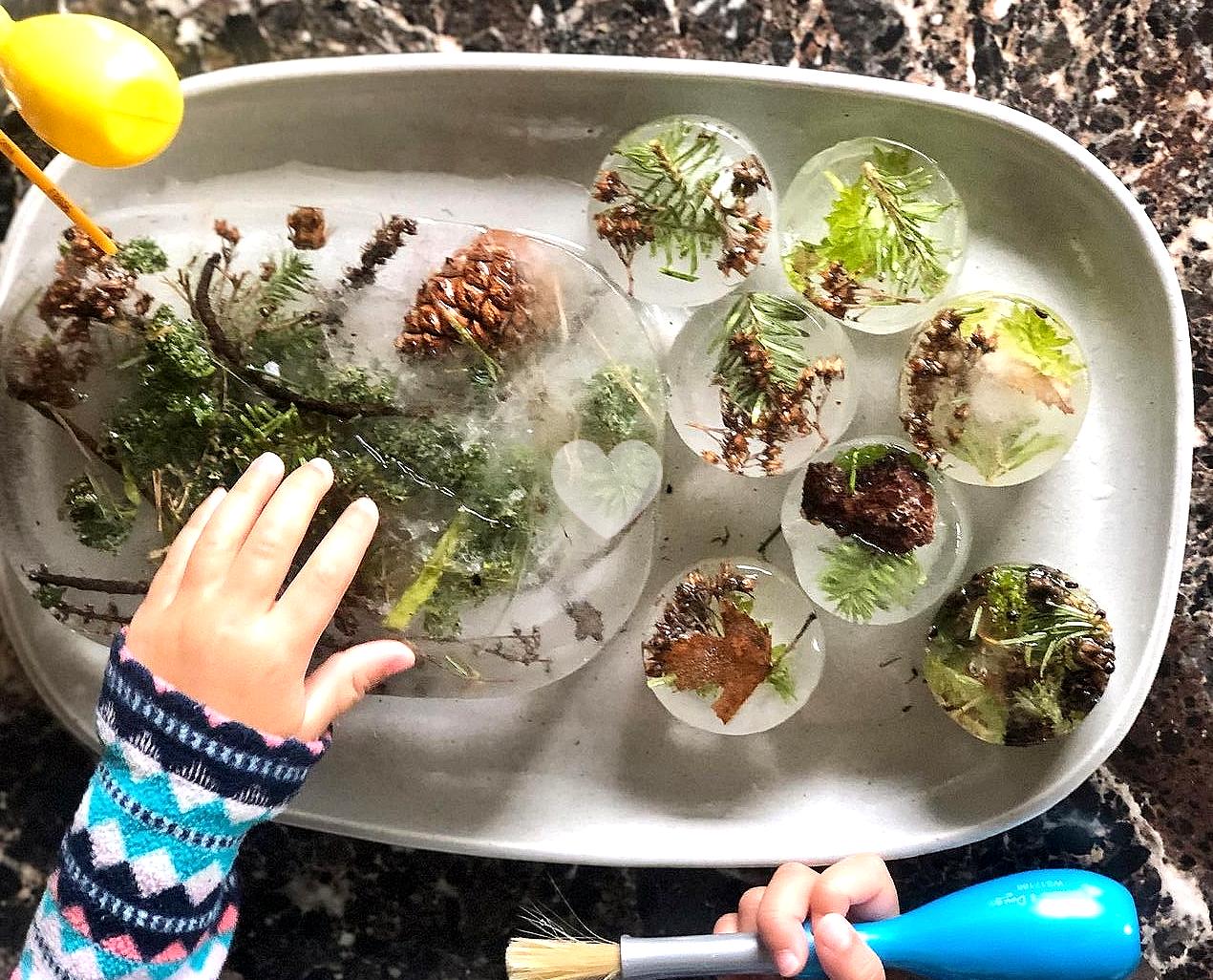 Toddler playing with plants in a nature-friendly indoor setting